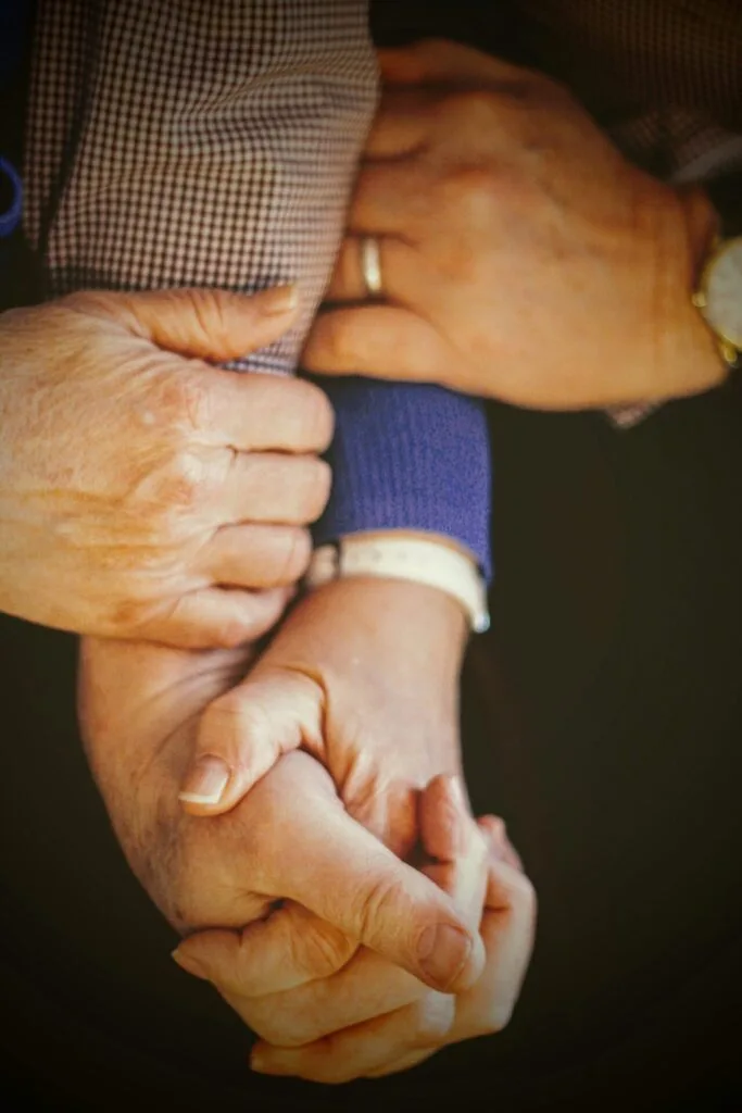 Mains entrelacées de plusieurs personnes, symbole de solidarité et de lien intergénérationnel.