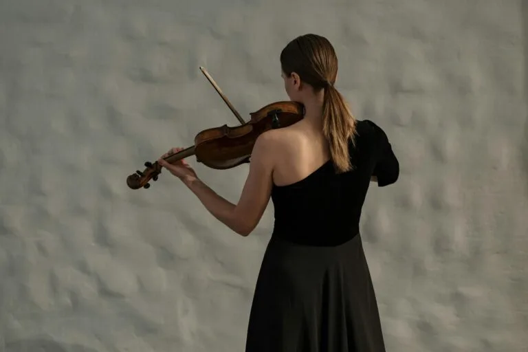 Lyrical Orchestra, violoniste jouant avec grâce, vue de dos, dans une ambiance minimaliste.